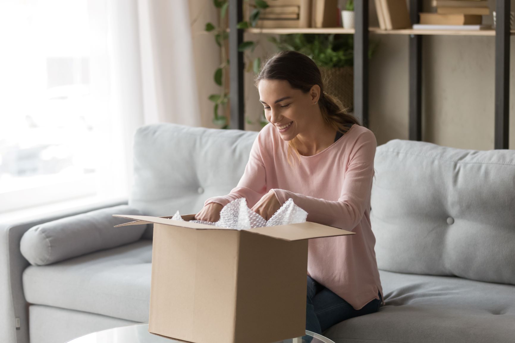 woman opening package happily